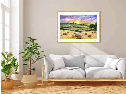 Fine art tisk Zlaté pole v přírodním dřevěném rámu zavěšený nad světlou moderní pohovkou, obklopený pokojovými rostlinami v minimalistickém interiéru.