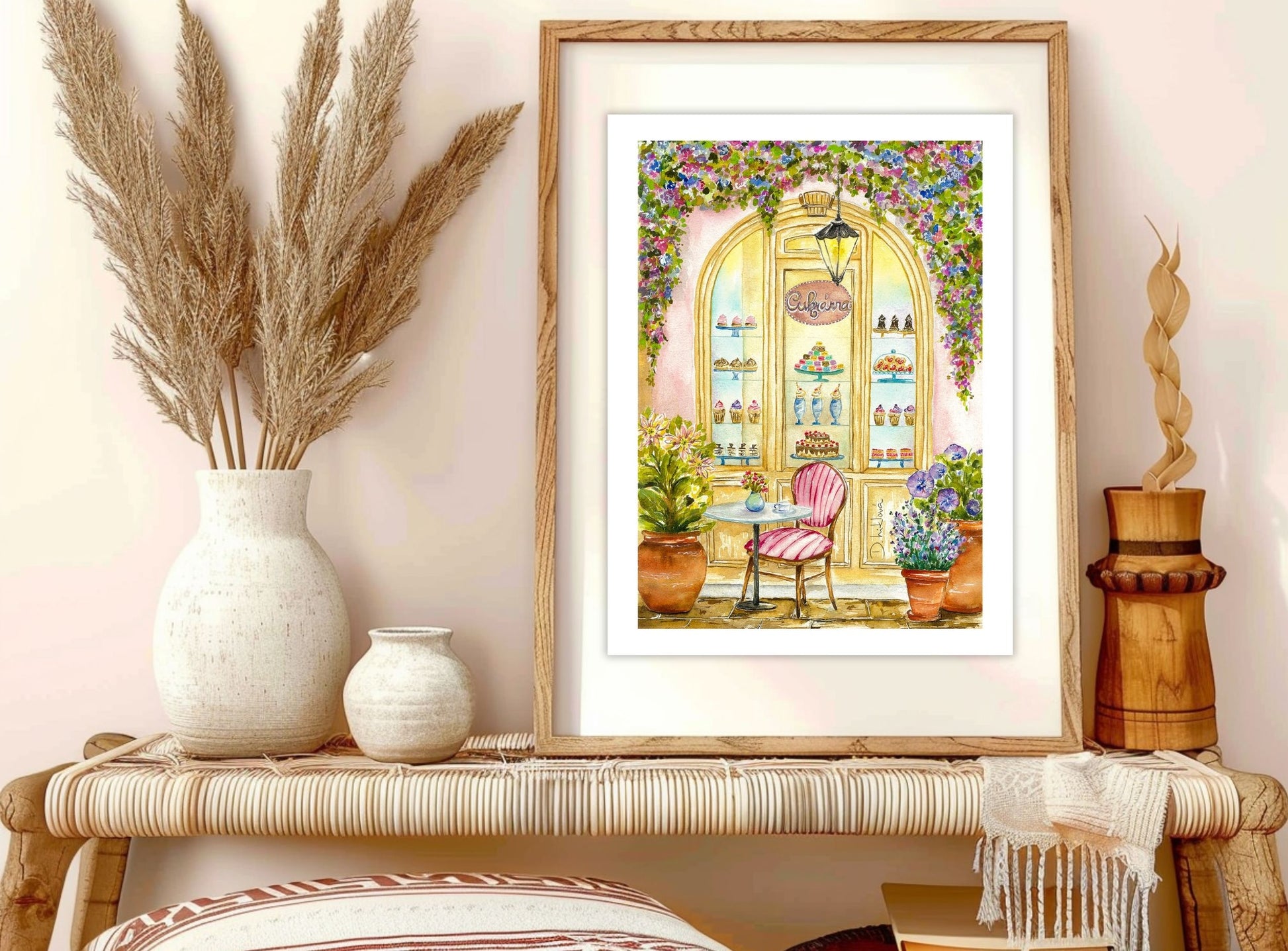 Fine art tisk Cukrárna v rámu na ratanovém stolku, dekorovaný sušenými travinami a keramickými vázami